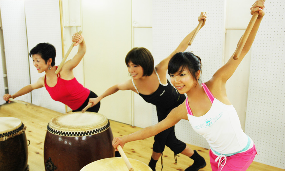 太鼓を叩きながらフィットネスする女性